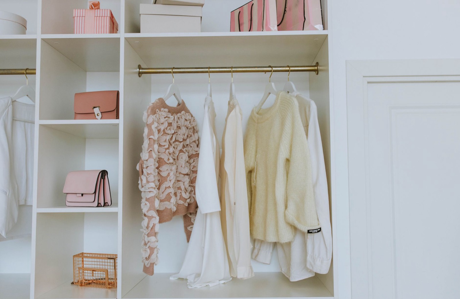 Shelved storage inside a wardrobe holding folded clothing and boxes