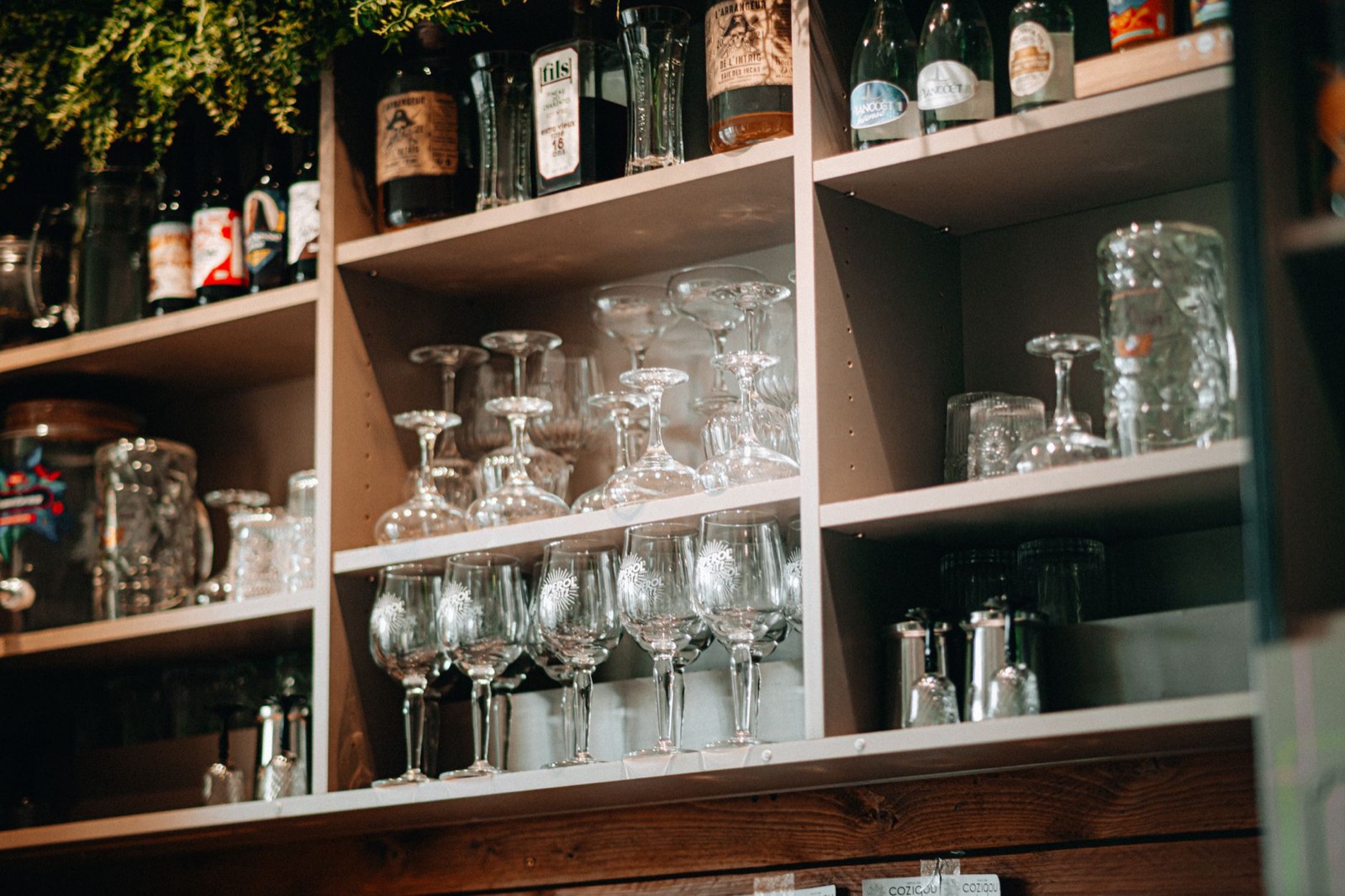 Enclosed bar cabinet holding bottles and glassware behind doors