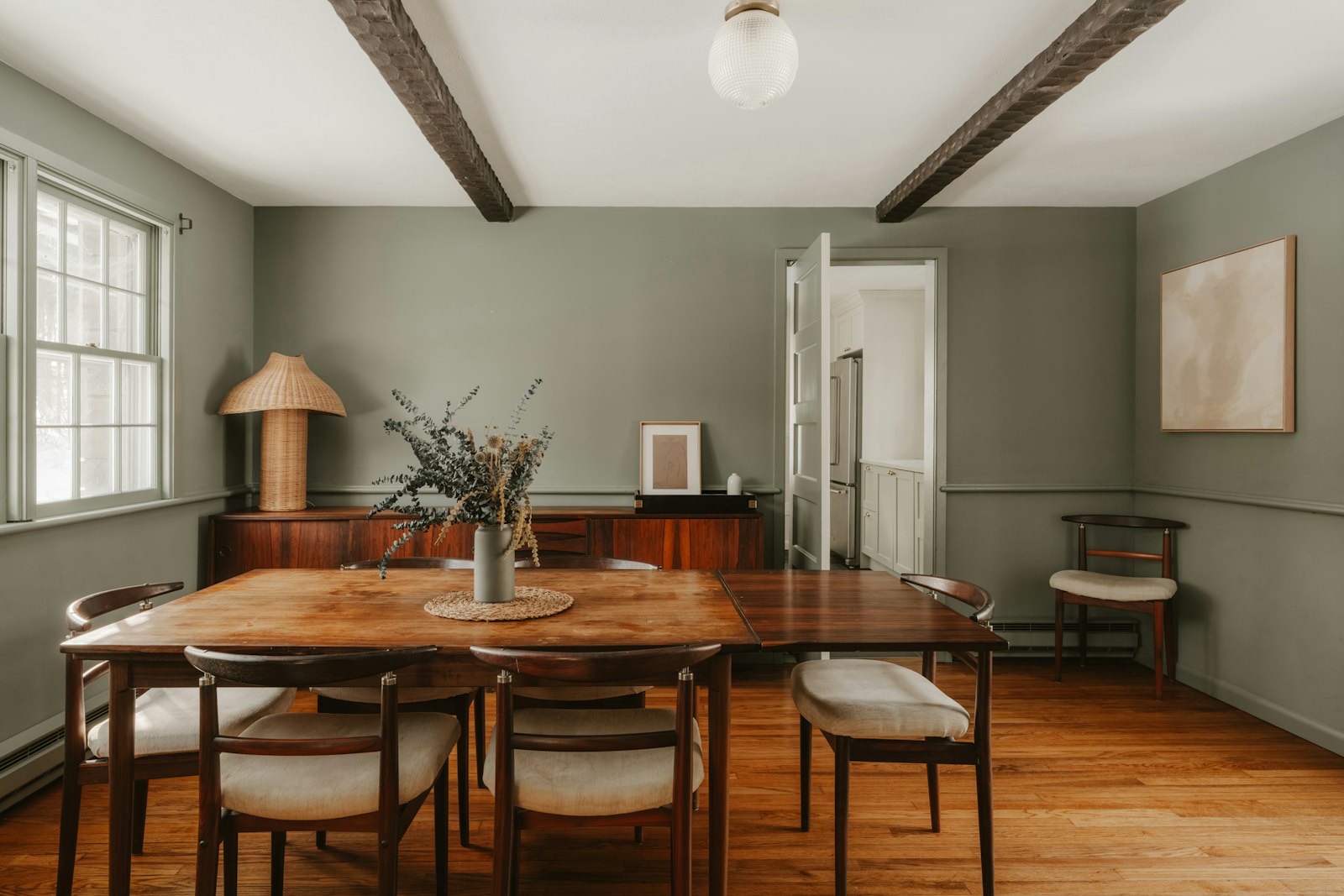 Sideboard positioned against a dining room wall beneath artwork