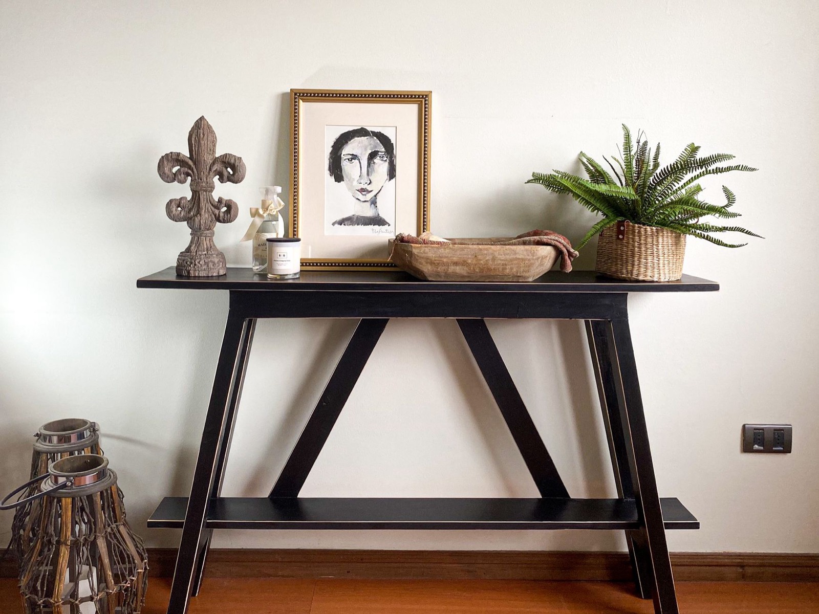 Console table styled against an entryway wall with objects arranged on top