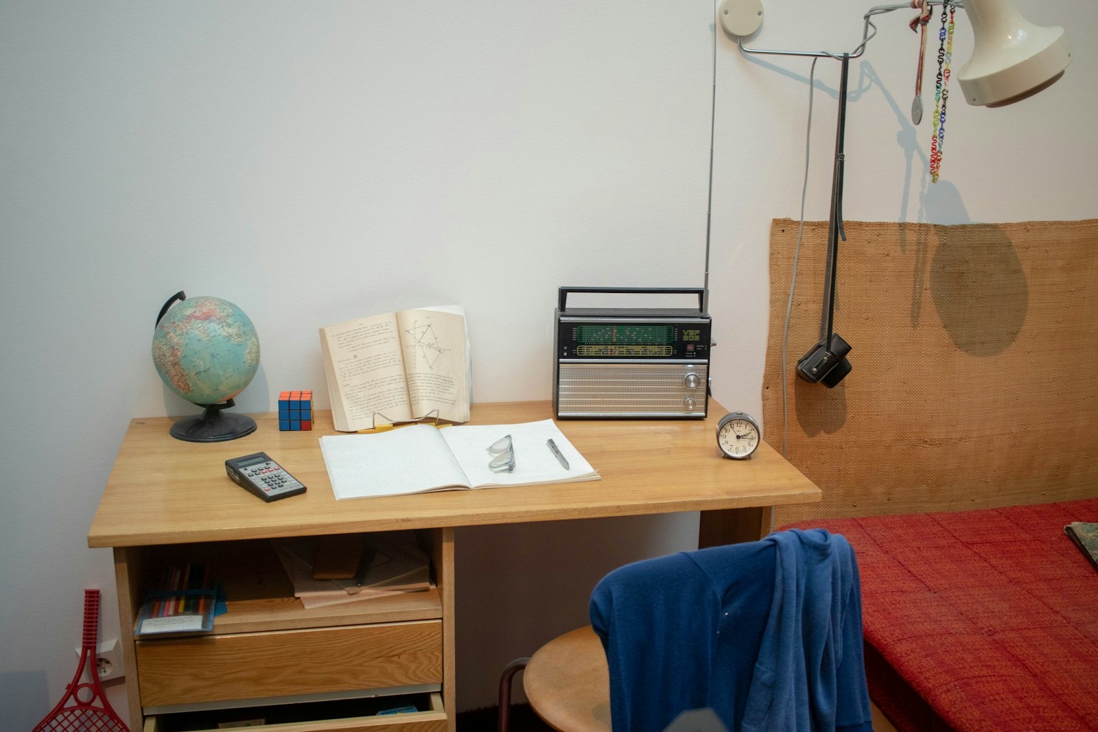Student desk with a lamp and books, the workspace already provided in most dorms