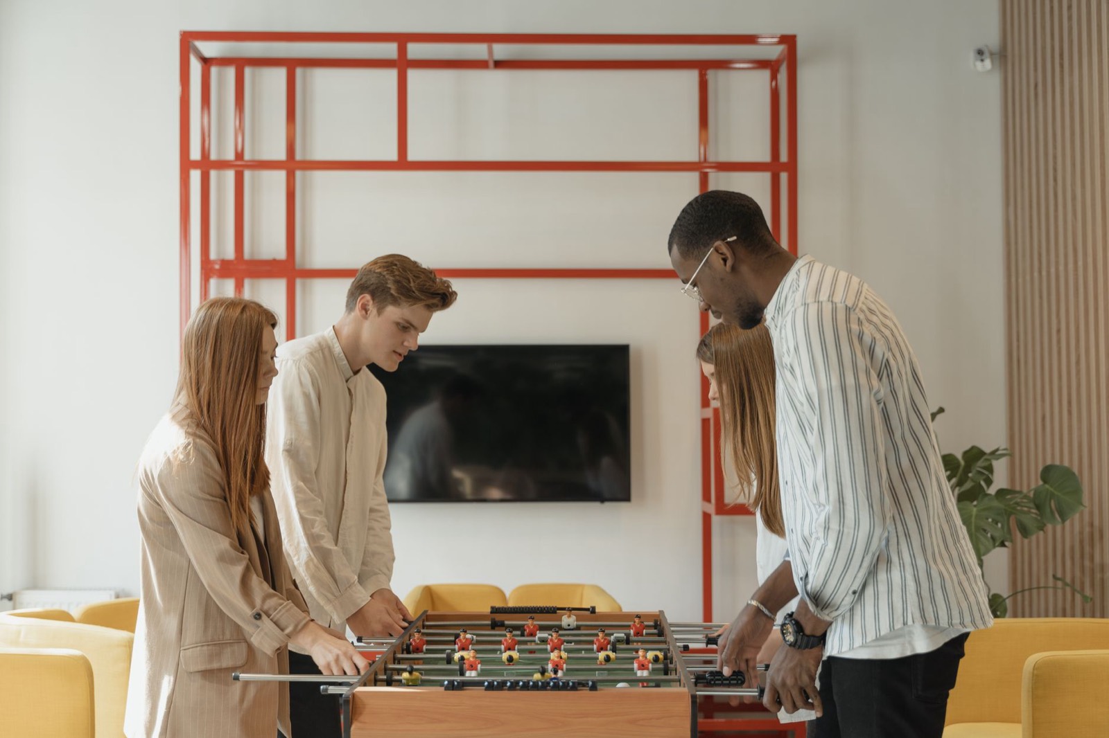 Foosball table in use, with rods extending beyond the table on both sides