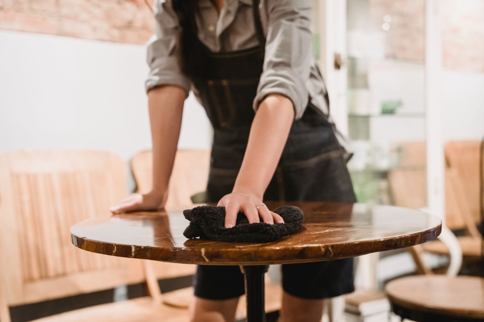 Wooden furniture surface being wiped with a soft cloth along the grain