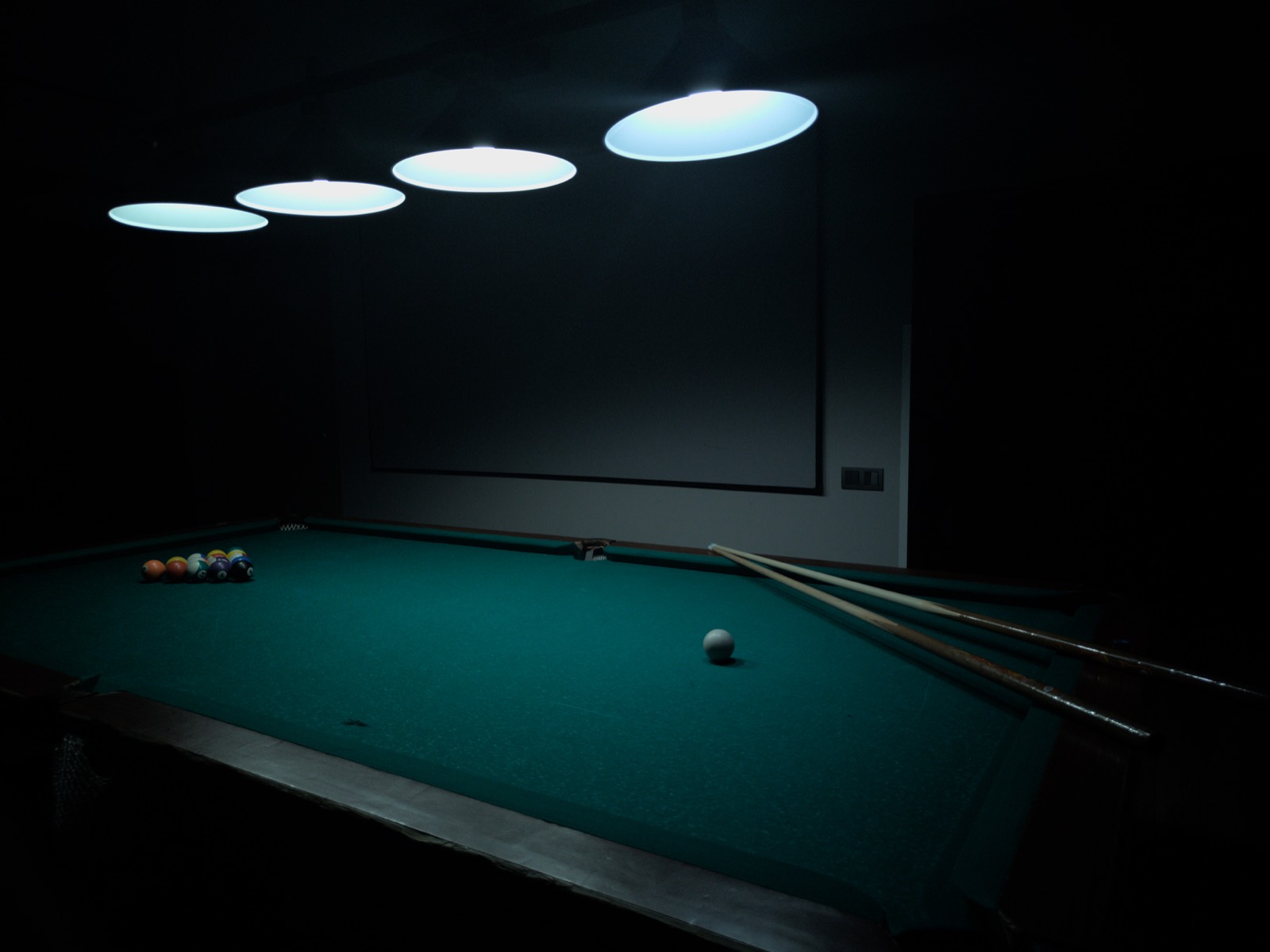 Pool table set in a games room with clear space around every side
