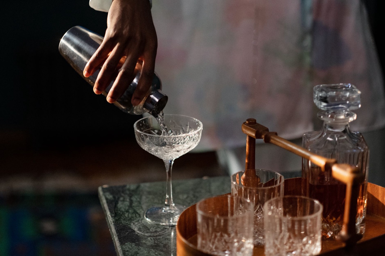 Bar cart styled with bottles and glassware in a living space