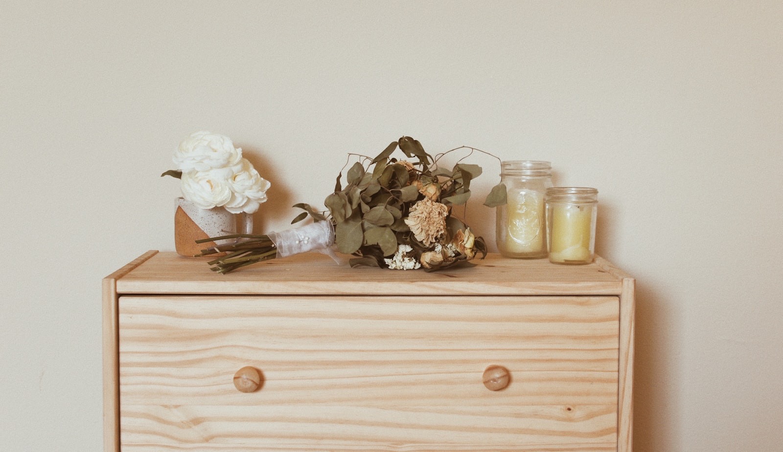 Wooden dresser with drawers positioned against a bedroom wall