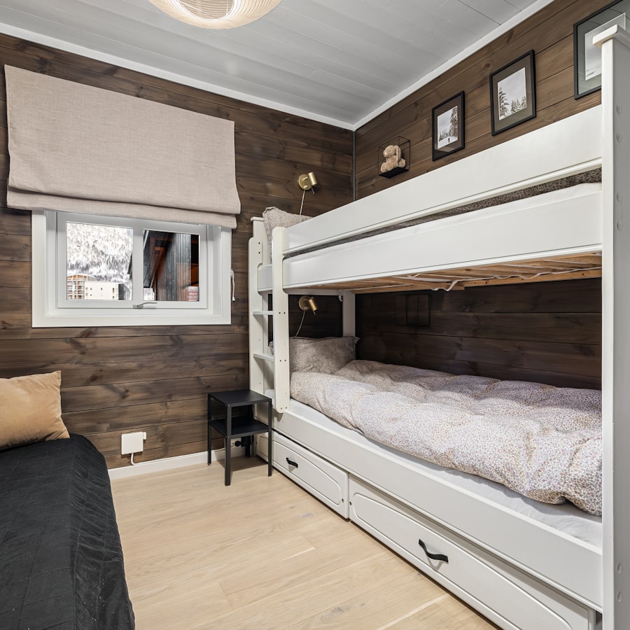 White bunk bed with storage in a cozy cabin-style room