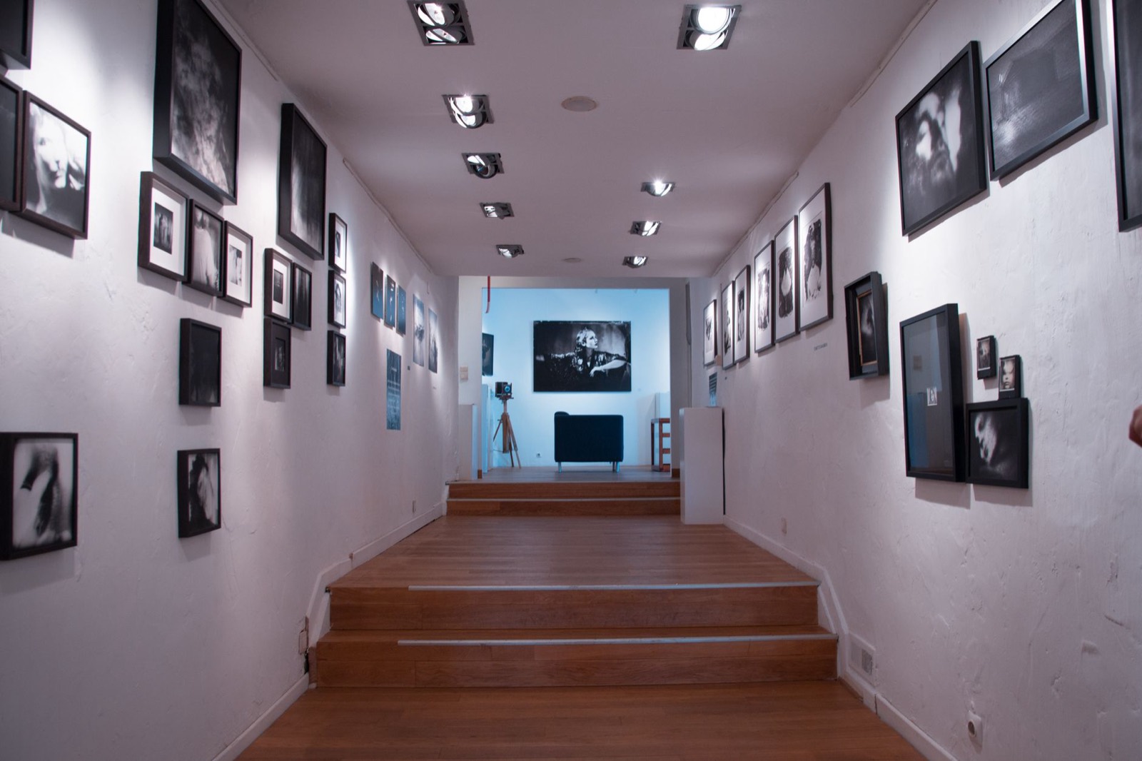 Framed pieces hung in a single line along a hallway wall