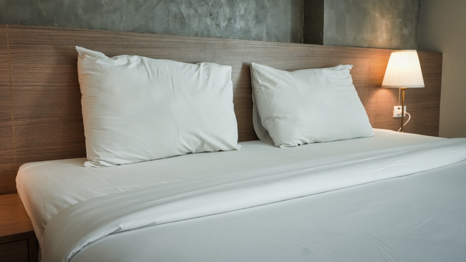 Made bed with clean white bedding layered over the mattress