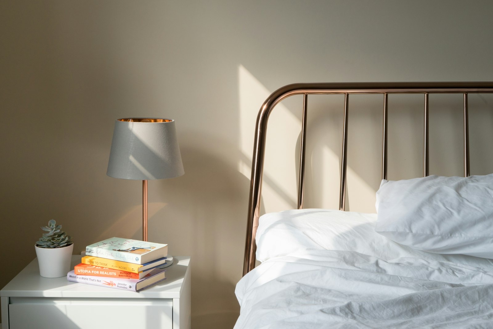 Nightstand beside a bed with a lamp, set at mattress height