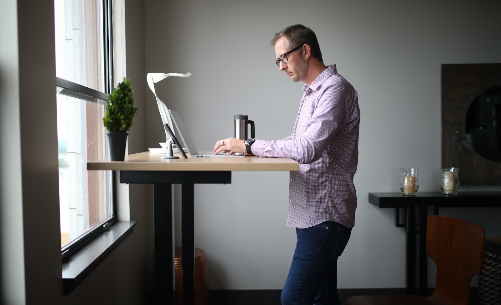 Height-adjustable desk allowing a change between seated and standing positions