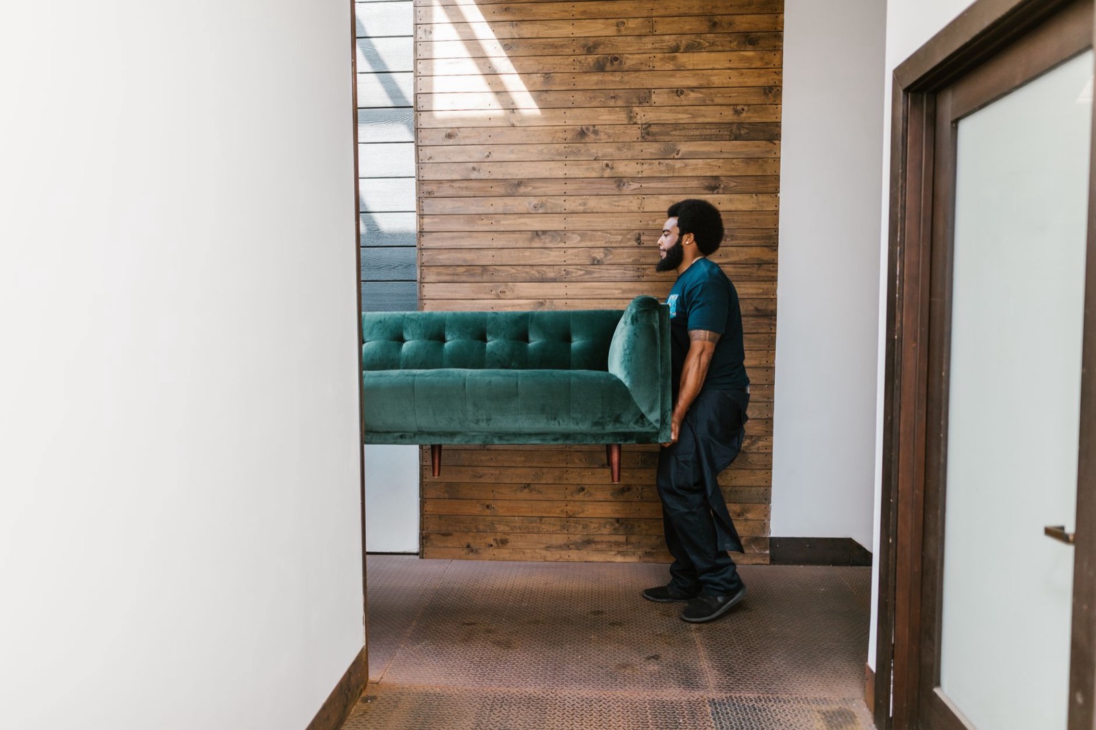 Two-person crew carrying a sofa into a home, the difference between threshold and full-service delivery